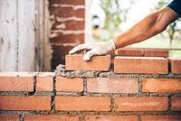 depositphotos_118621026-stock-photo-industrial-bricklayer-worker-placing-bricks